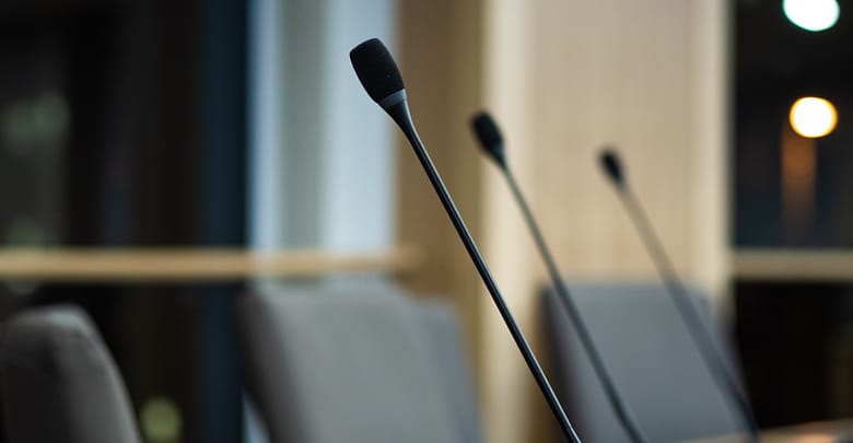 close up of microphones in a council chamber candidates